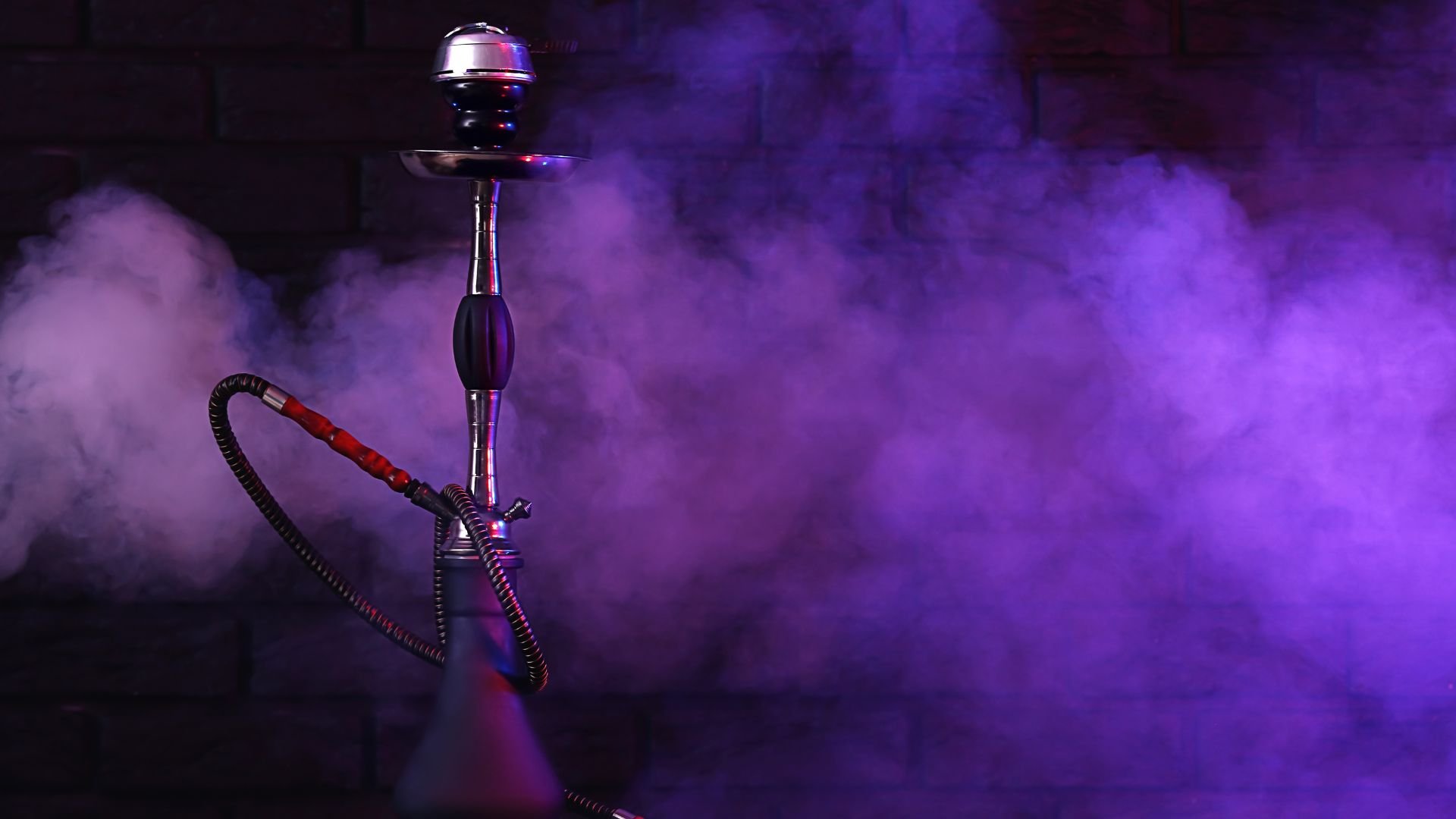 Shiny hookah with purple smoke against dark atmospheric background