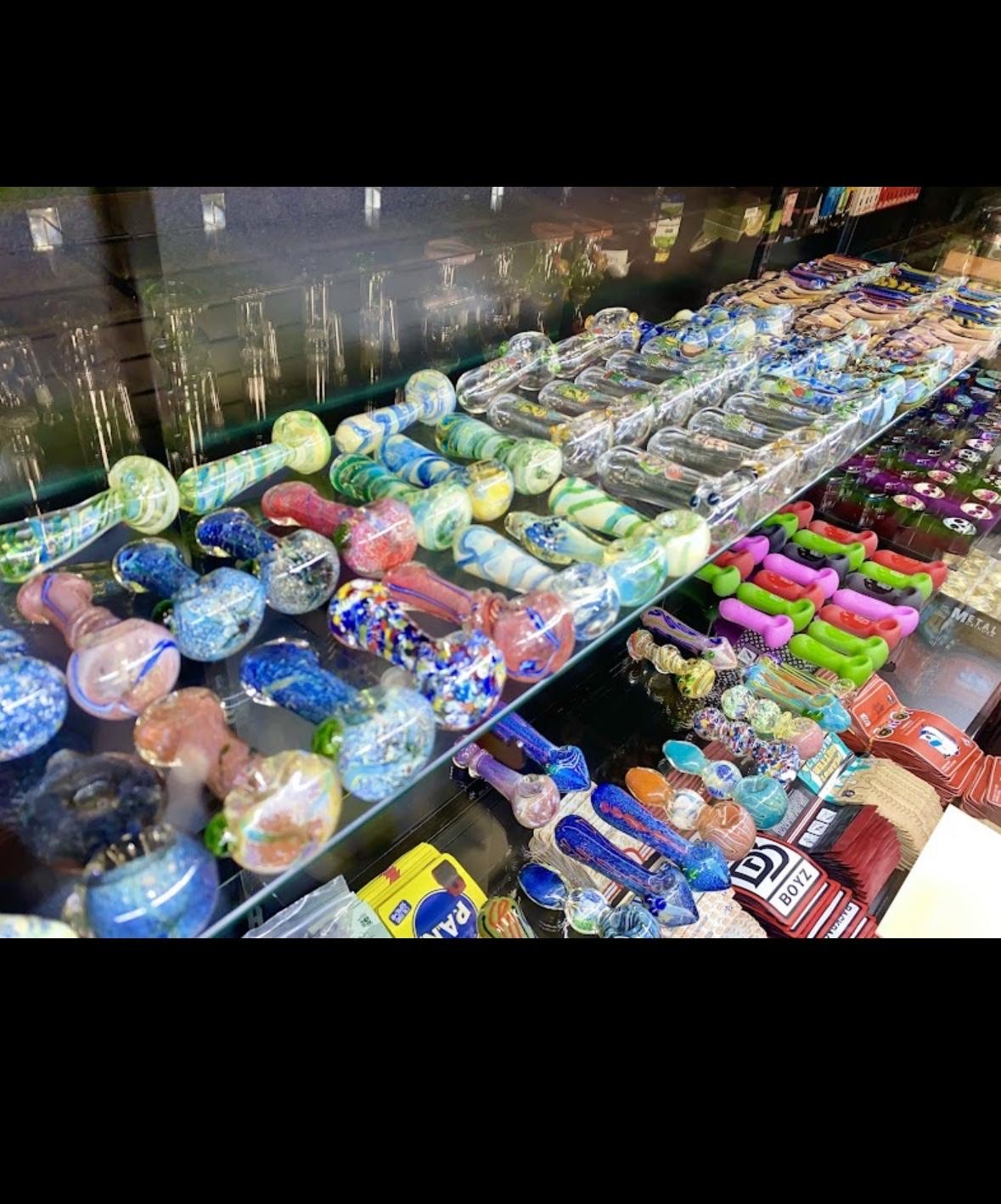 Colorful glass pipes and smoking accessories displayed in a retail showcase
