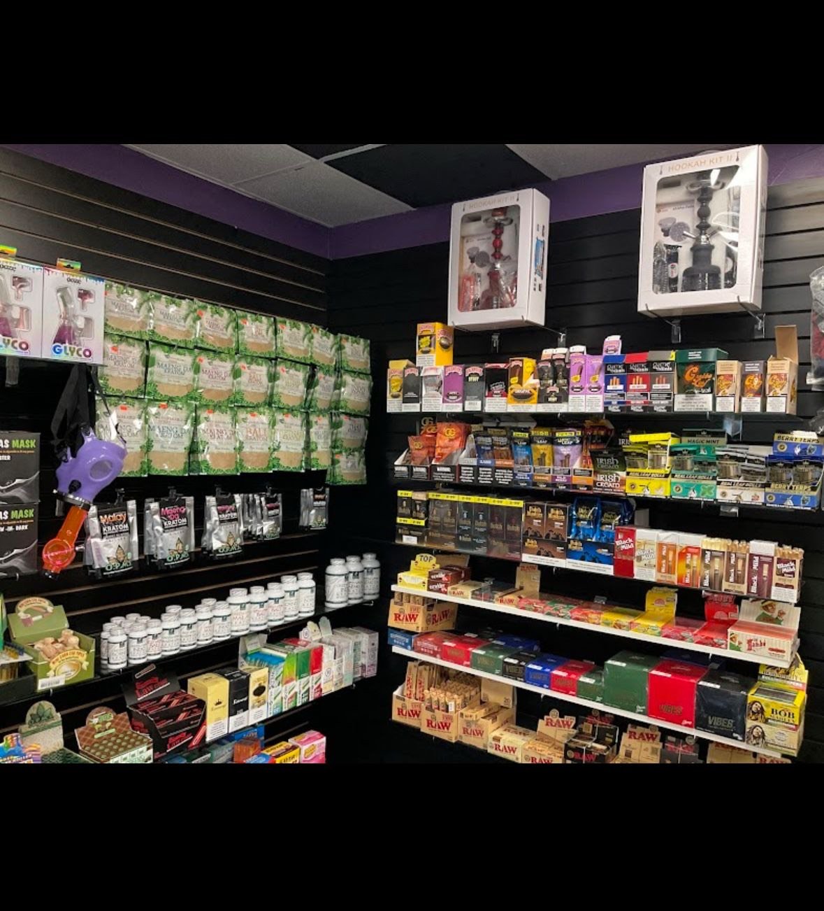 Smoke shop interior with shelves of tobacco, smoking accessories, and supplements