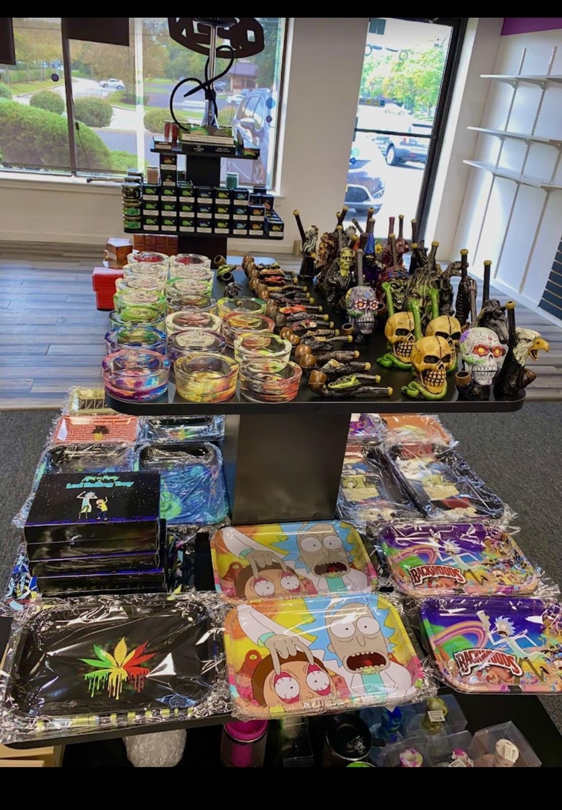 Smoke shop display with colorful glass, skull pipes, and Rick and Morty trays
